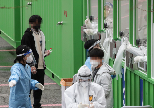 지난 10일 오후 서울 송파구 잠실종합운동장 제2주차장에 추가로 설치된 신종 코로나바이러스 감염증(코로나19) 거점형 검사소에서 의료진이 검사하고 있다. <연합뉴스>